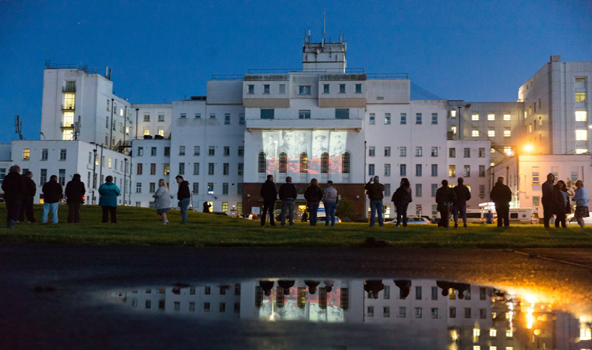 People gather outside St Helier as the sky gets darker